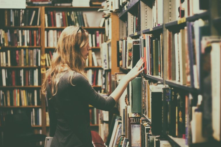 Kvinde leder efter bøger på bibliotek
